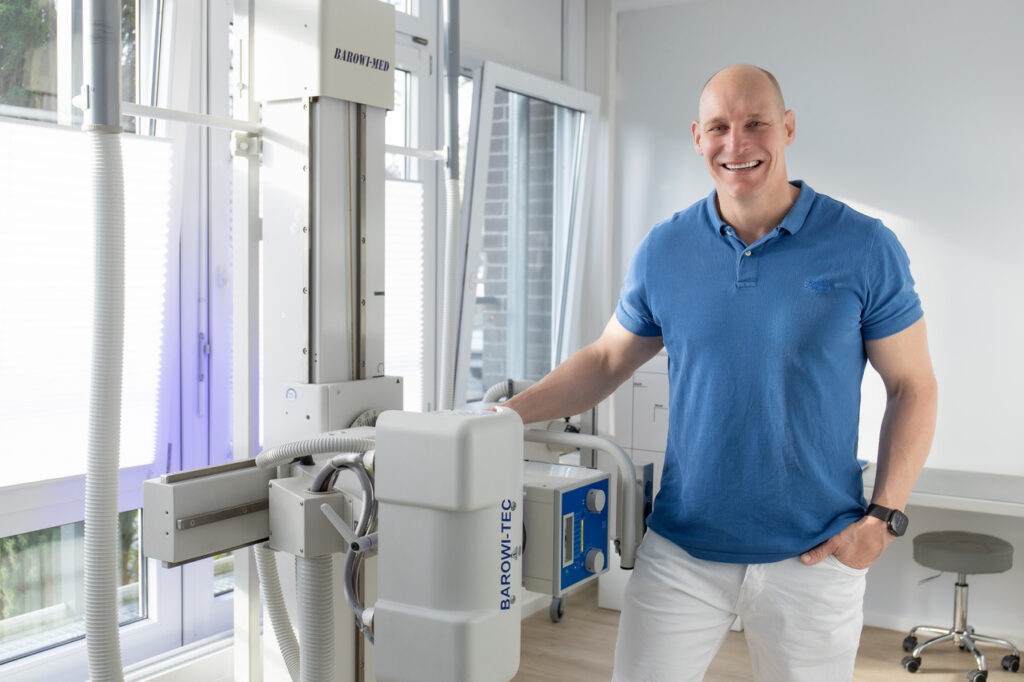 Dr. med. Alexander Mann neben dem digitalen Röntgengerät
